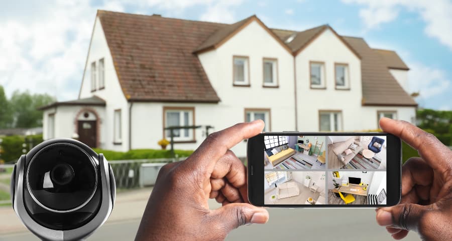 Man holding mobile device and viewing streams from surveillance cameras